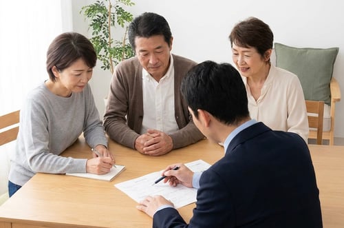 family sitting at kitchen table working with their financial planner on 2026 tax strategies